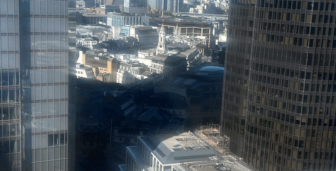 Tall buildings the City of London with a blue sky behind